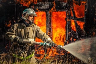 Пожарный тушит пожар